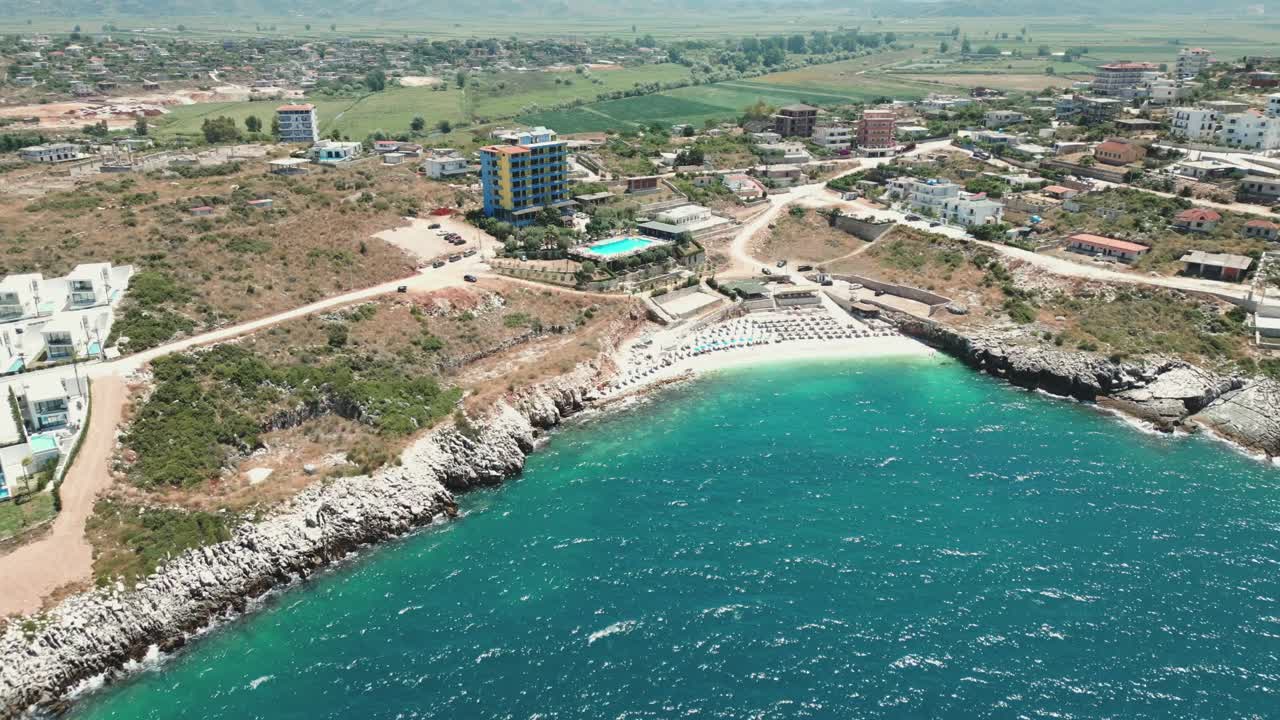 albania, las aguas azules del mar jónico, playa de guijarros con paraguas y acantilados
