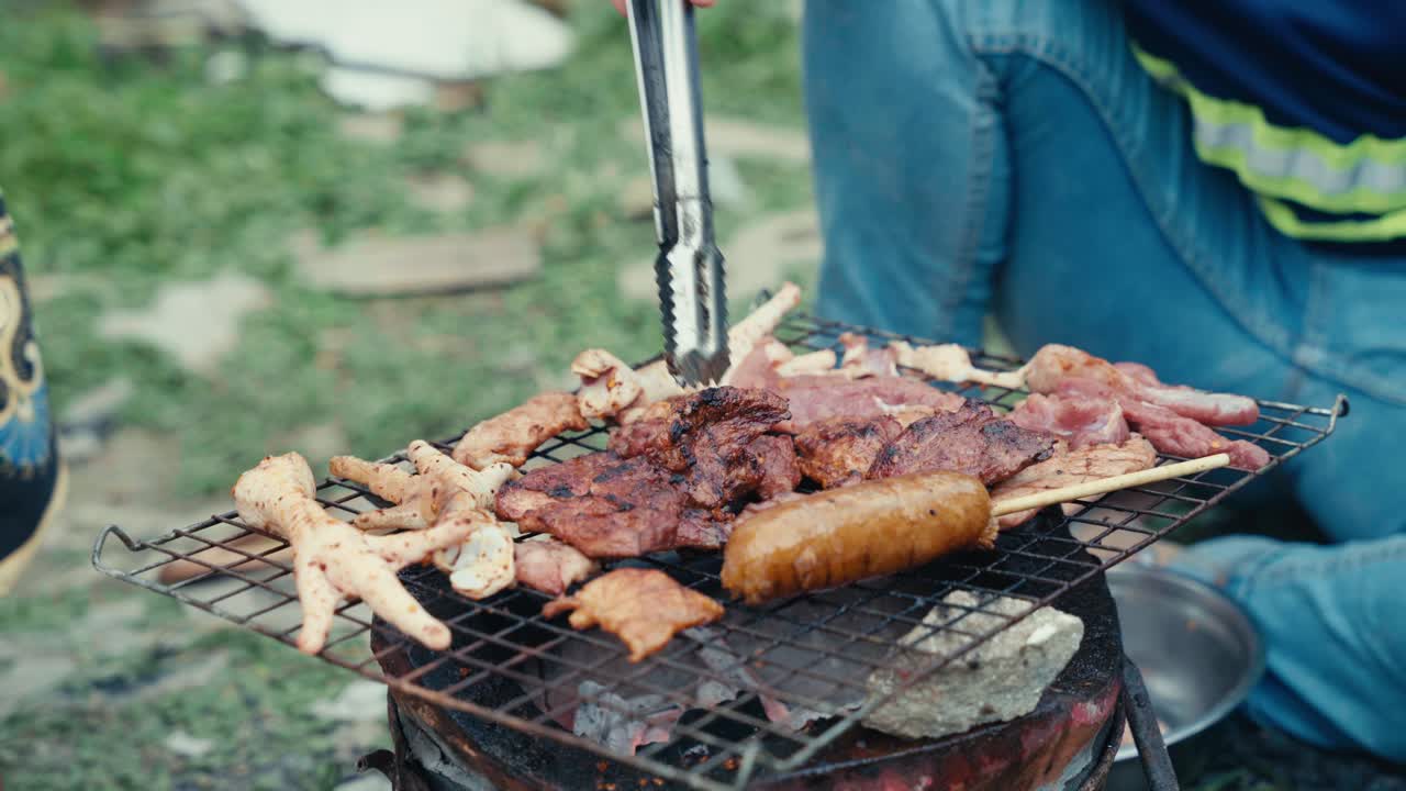 タイの低所得者層の地域でバーベキューのグリルで焼かれる食品や肉。夜に照らされ、地元の屋台料理、日常生活、本場の都市文化が表現されています。