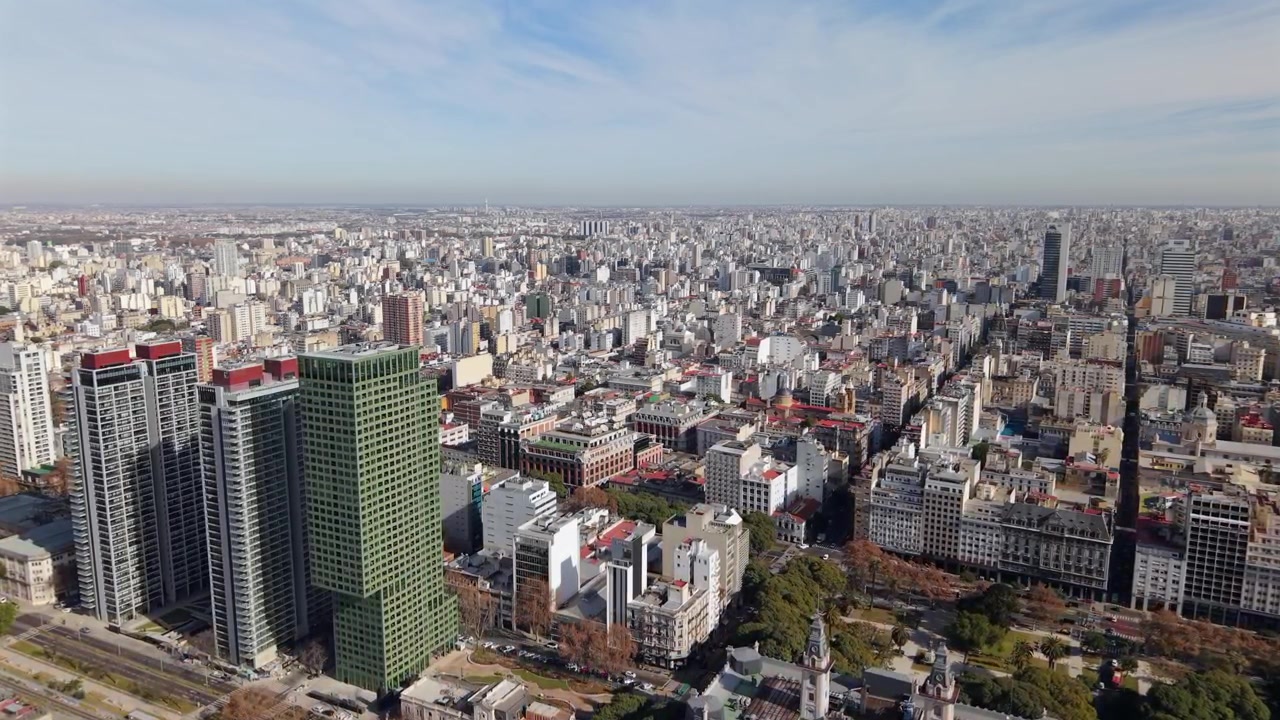 Grattacieli per uffici a Puerto Madero, che si affacciano sul vasto centro di Buenos Aires e sullo skyline durante un pomeriggio soleggiato. Ripresa aerea fluida in avanti.