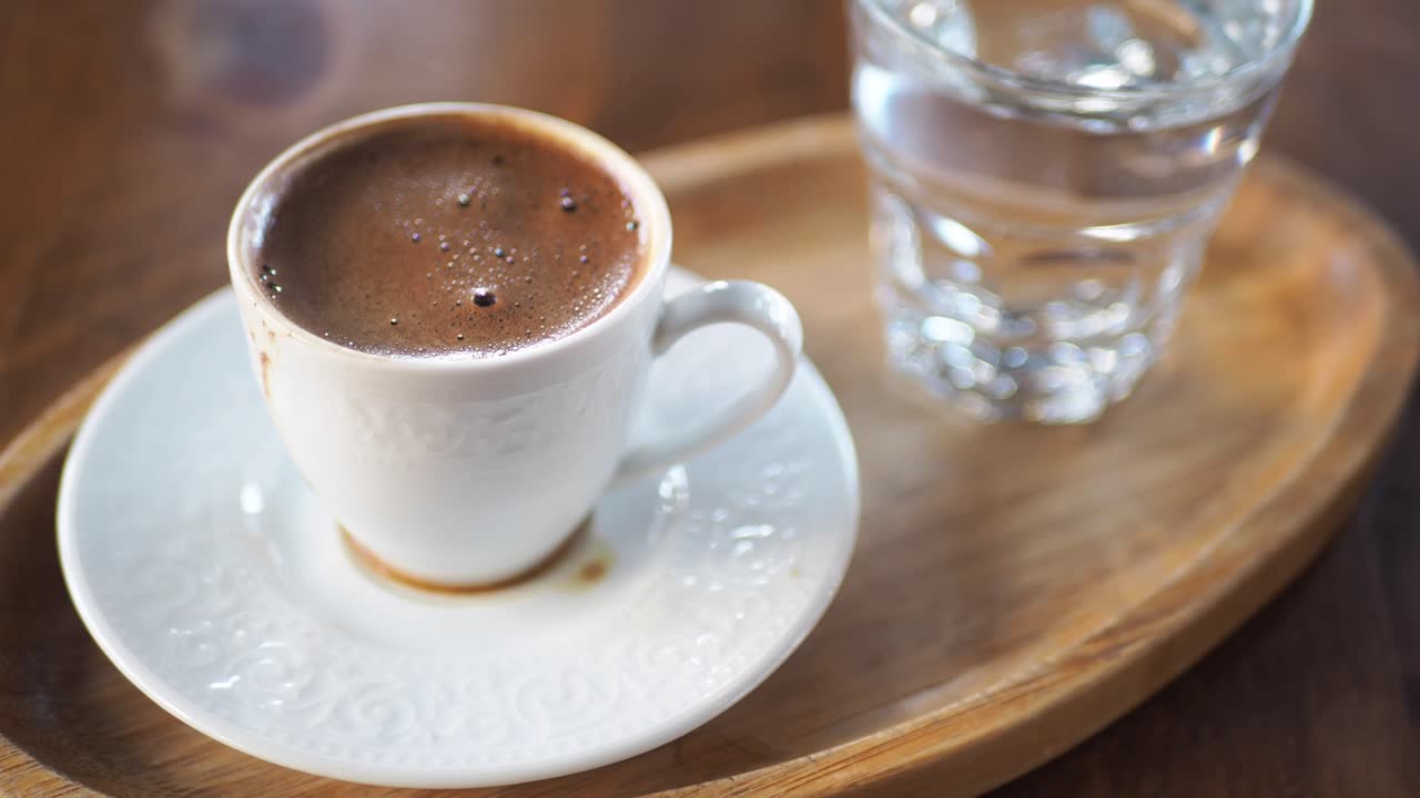 una taza de café turco con un vaso de agua