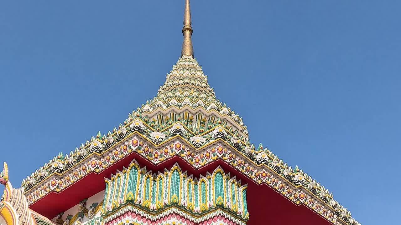 Close-up views of ornate temple pillars and roof against a clear blue sky.