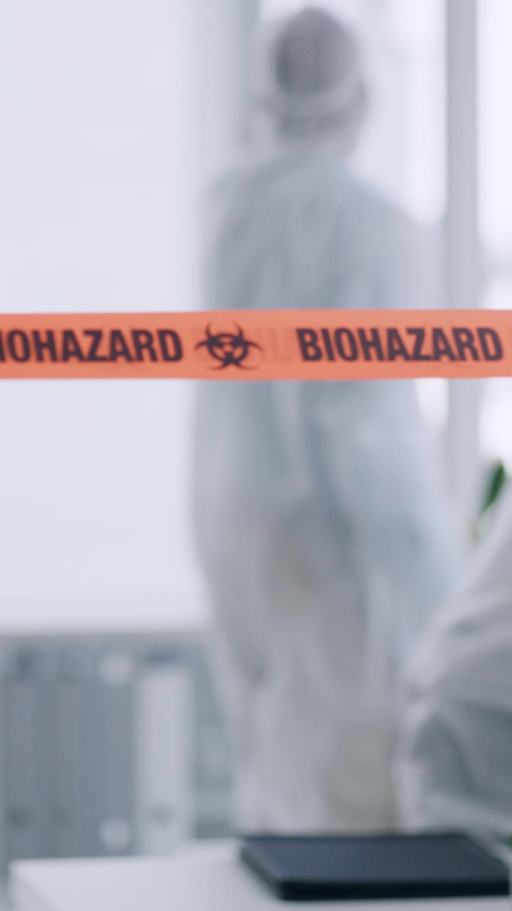 Cientista aplicando fita de aviso de risco biológico em laboratório