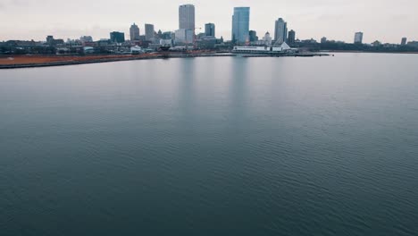 Drone-Volando-Bajo-Sobre-La-Superficie-Del-Mar-De-Agua,-Frente-Al-Mar-De-La-Ciudad-De-Milwaukee,-Estados-Unidos