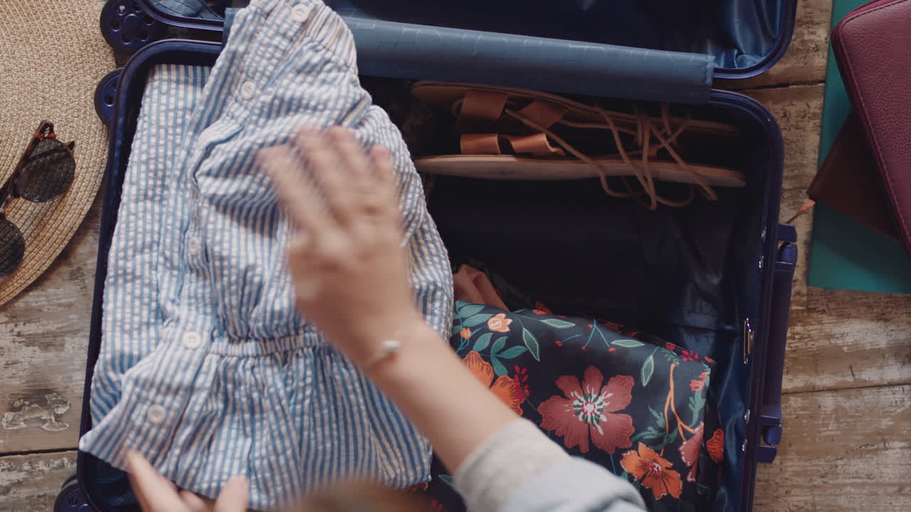 탑 뷰 여행 여자 가방 을 포장 하고 도로 여행 을 위해 준비 하고 휴가를 위해 짐 을 준비 하고 있다