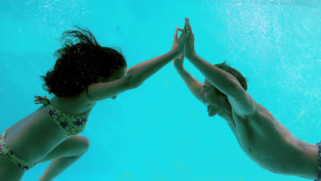 Feliz-Pareja-Tomados-De-La-Mano-Bajo-El-Agua-En-La-Piscina