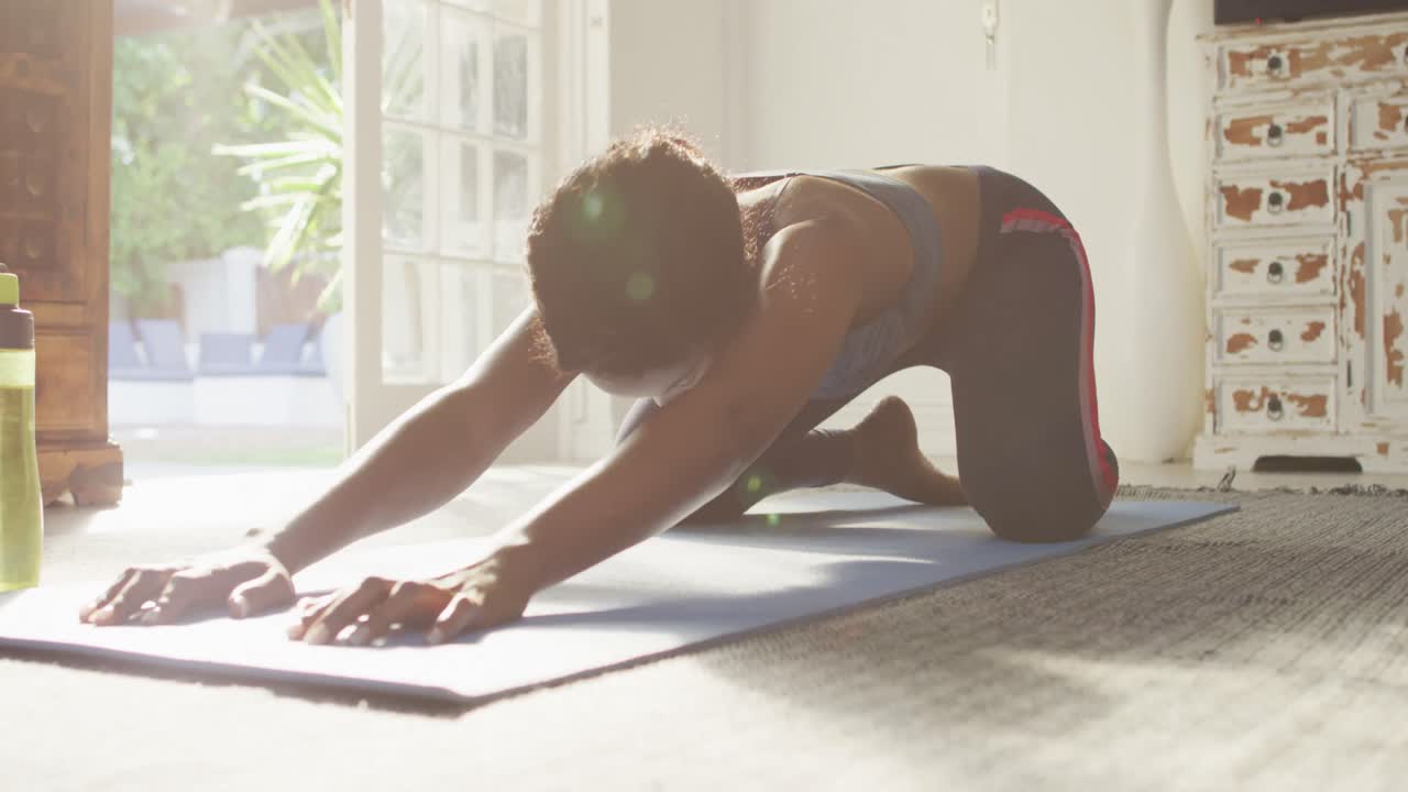 video de una mujer afroamericana practicando yoga en casa