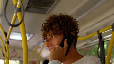 male commuter talking on mobile phone while travelling in bus 4k