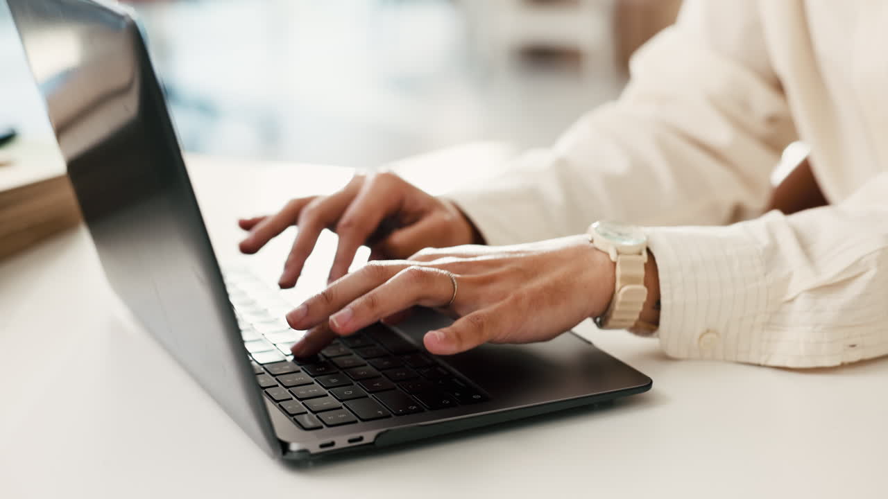 Close-up of Person's Hands Typing on Laptop Keyboard