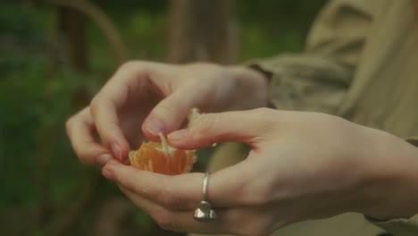 una mujer pelando una naranja.