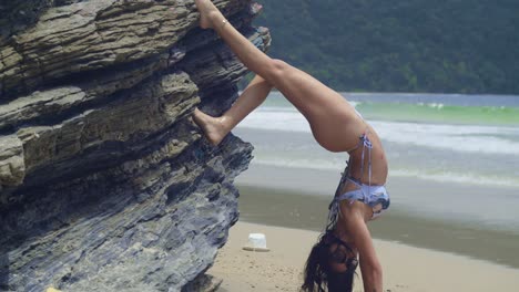 A-girl-in-a-bikini-savors-the-beauty-of-a-Caribbean-beach,-surrounded-by-powdery-white-sand-hand-stand-pose-on-the-beach