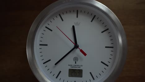 reloj blanco haciendo tictac en un escritorio de madera