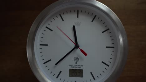 white clock ticking on wooden desk