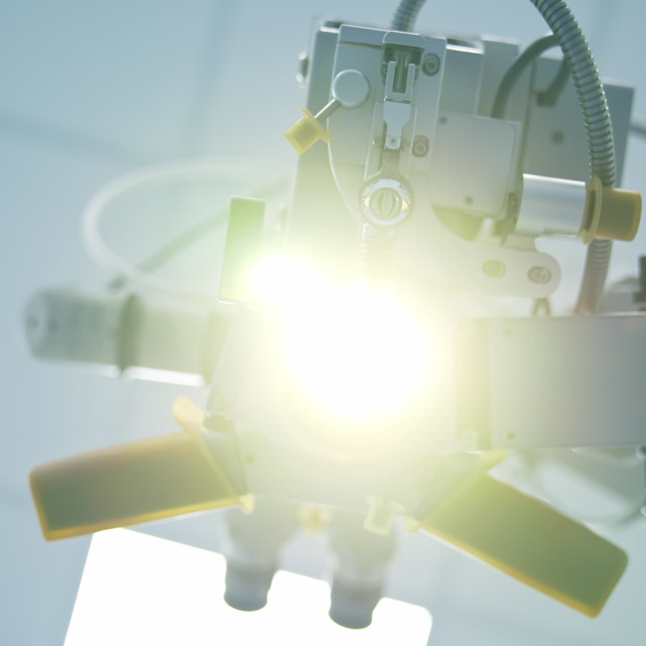 Light coming from the equipment used for eye surgery. Footage of the device from a patient's position. Close up