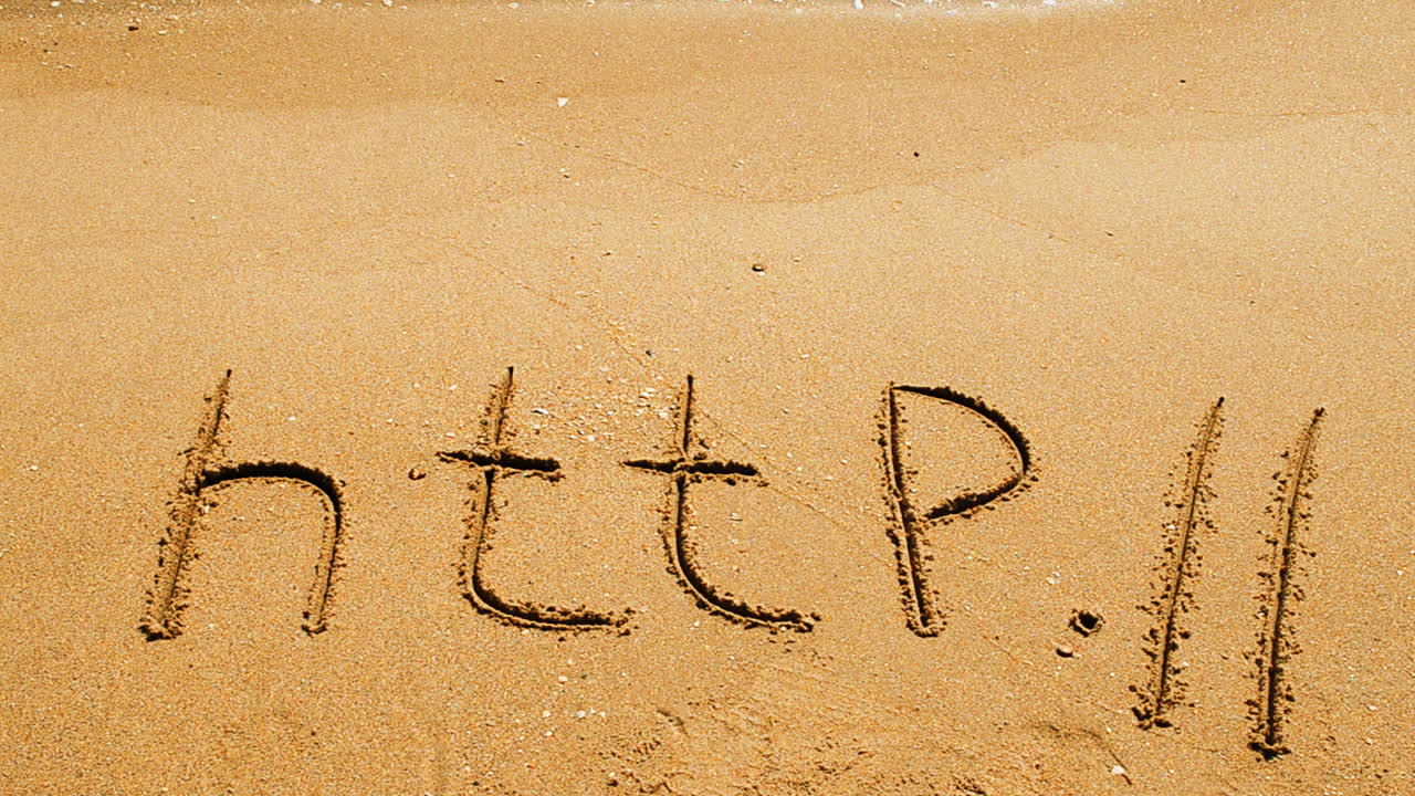 Ordet http håndskrevet i sand på en strand. Optagelse på stranden.