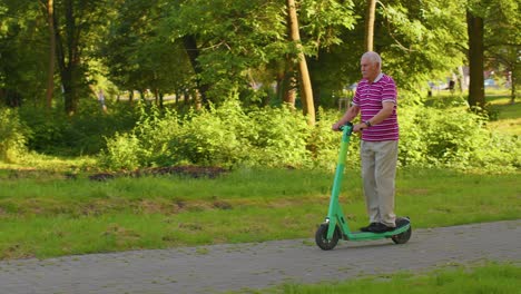 Hombre-Mayor-Con-Estilo-Abuelo-Turista-Montando-Scooter-Eléctrico-En-El-Parque,-Vida-Moderna-Después-De-La-Jubilación