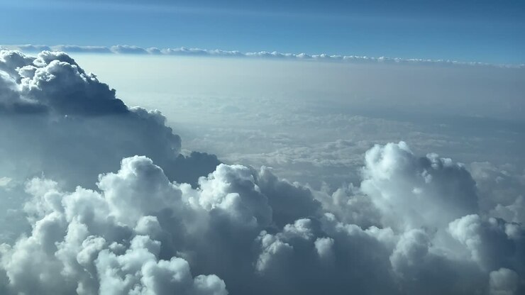 Unique immersive pilot POV in a real time flight though a blue sky overflying some stormy clouds doing a right turn to avoid bad weather