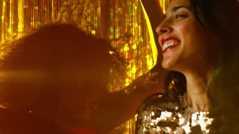 close up of two women dancing in nightclub bar or disco drinking alcohol with sparkling lights 9