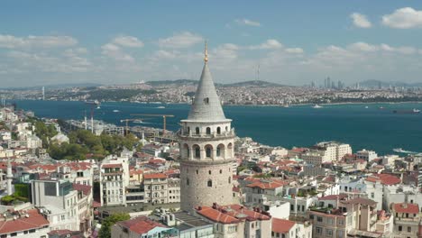slowly circling around galata tower in istanbul, turkey with view over skyline and bosphorus, slow aerial drone view