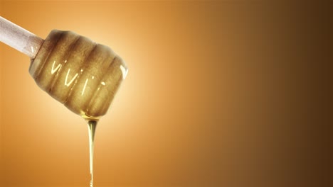 Honey dripping from honey dipper on orange background