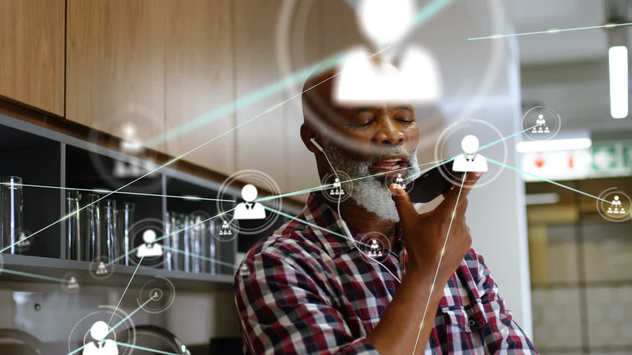 Animation of network of connections with people icons over biracial businessman using smartphone