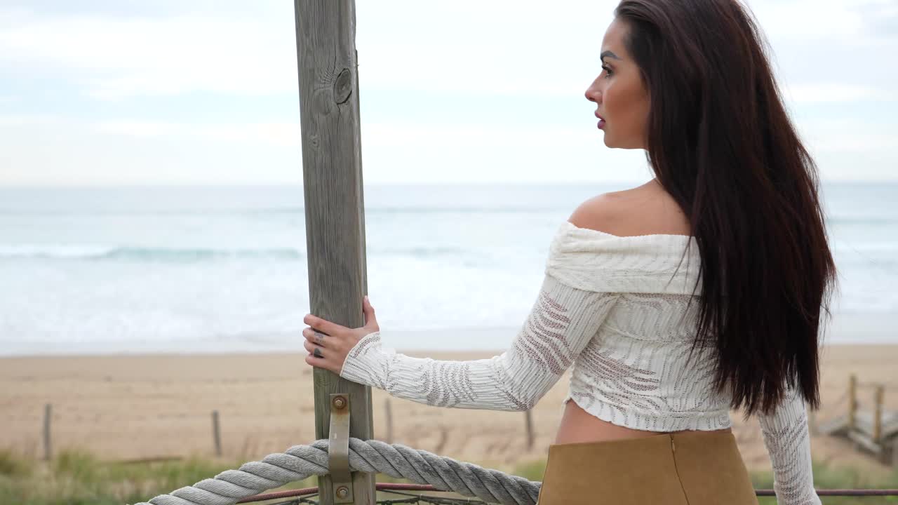 Woman on a wooden bridge at the beach