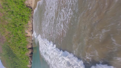 Drone-flying-over-waves-along-Playa-Caleton-beach,-Dominican-Republic