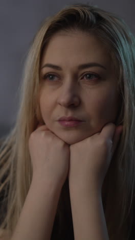 mujer rubia estresada con cabello rubio desordenado sufre de depresión y emociones negativas en una habitación semi-oscura con lámpara encendida visión extrema de cerca cámara lenta