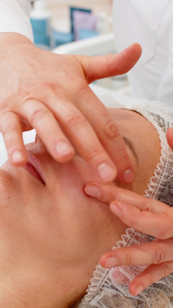 Cosmetologa applica crema contorno occhi SPF su donna caucasica dopo un trattamento viso per la cura della pelle in una clinica spa