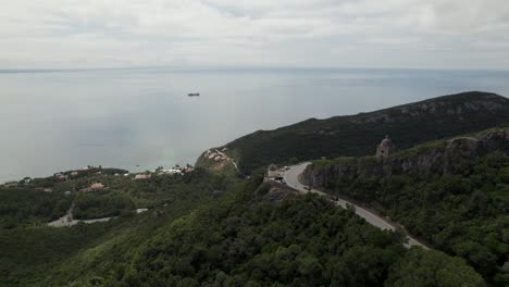 cars driving along panoramic road of serra da arrabida with sea in background, setubal peninsula, portugal