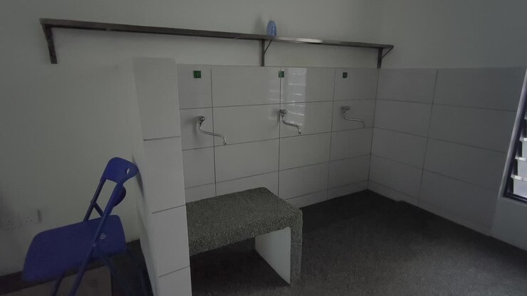 A close-up of a clean ablution area at a small Malaysian highway prayer room. Water flows for ritual washing as travelers prepare for prayer
