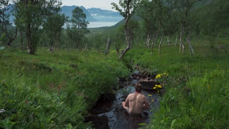 Un-Hombre-Caucásico-Bañándose-En-El-Arroyo-De-Un-Río