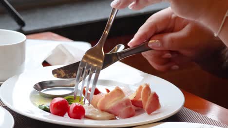 persona metiendo tomates con un tenedor en el plato