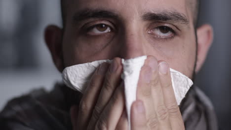 closeup of man that sneezes, coughs and cleans his nose