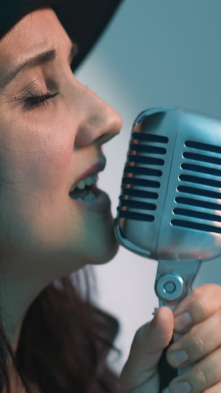 검은색 셔츠와 모자를 입은 노인, 안경을 착용하여 사려 깊게 반영하고, 부드럽게 흐릿한 다채로운 빛의 배경에 대해 프로파일로 포착하여 깊고 상적인 분위기를 강조합니다.