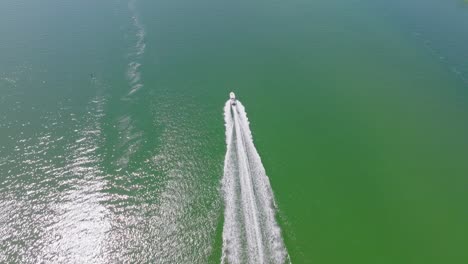 white speed boat cruising on emerald waters