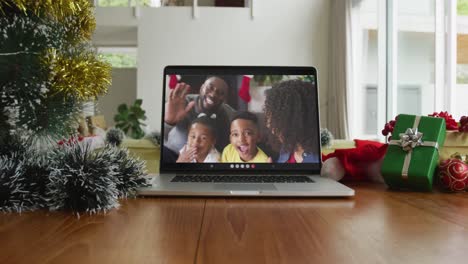 Familia-Afroamericana-Sonriente-Saludando-En-Una-Videollamada-Navideña-En-Una-Computadora-Portátil