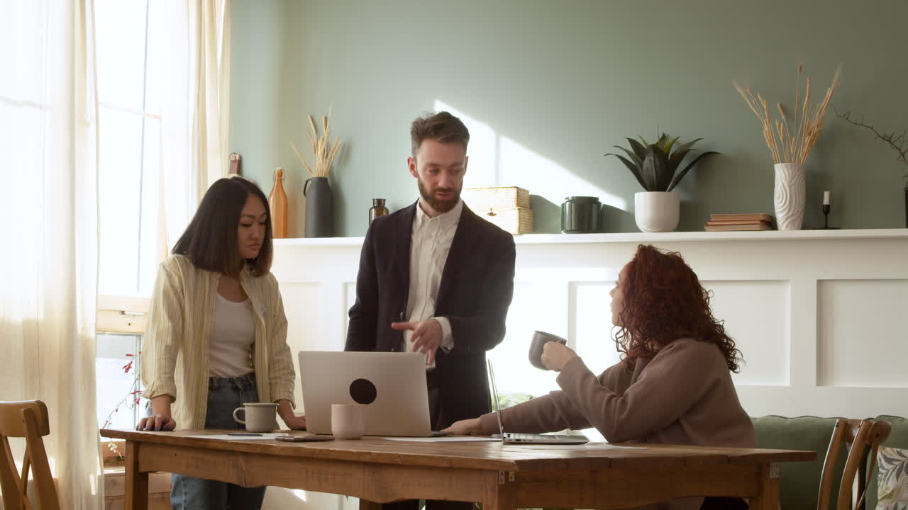 Multiethnic Young Colleagues Having A Debate While Looking At Laptop Computer During A Team Meeting