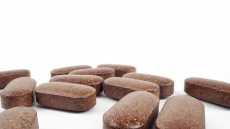 array of herbal brown tablets on a clean white backdrop