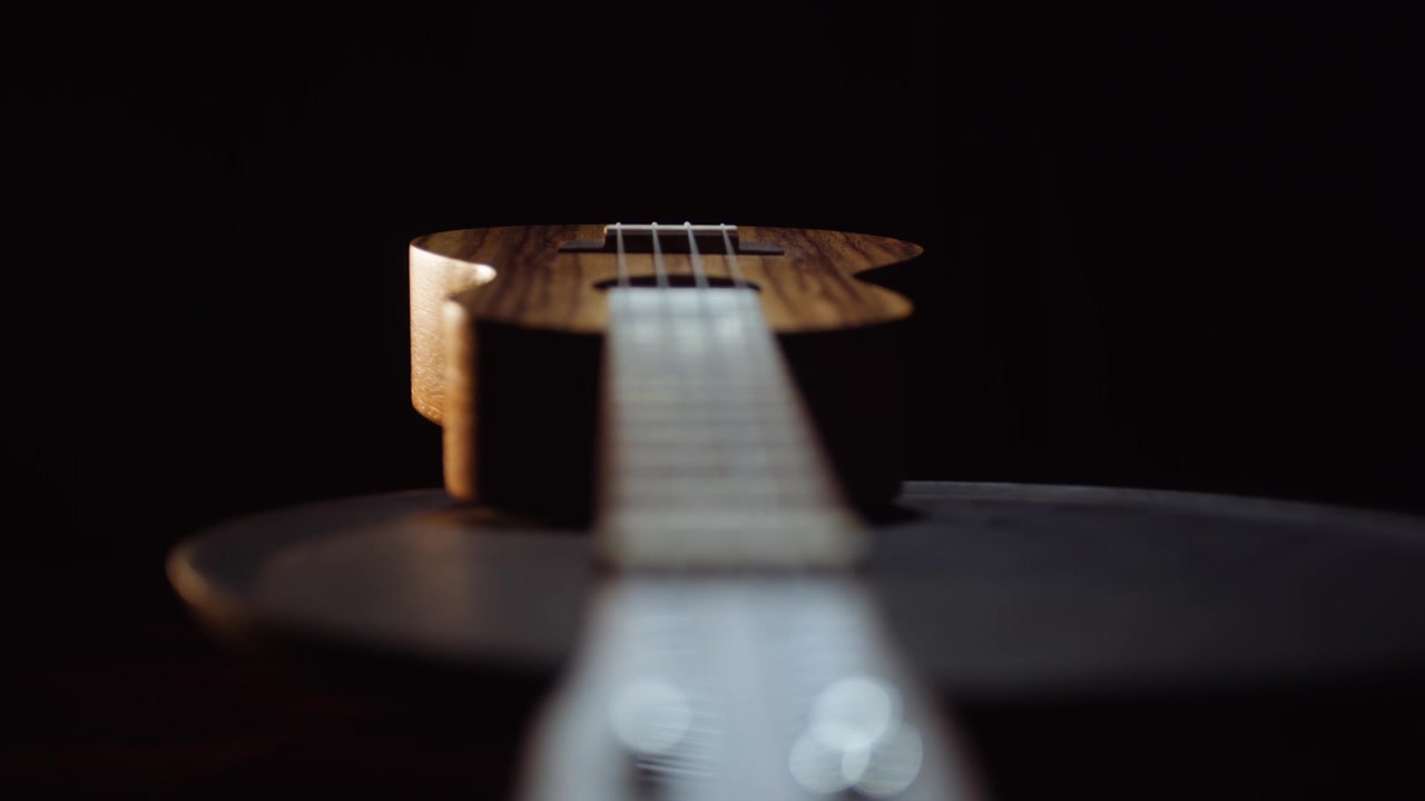 Ukulele su sfondo nero. Ukulele, strumento a corde