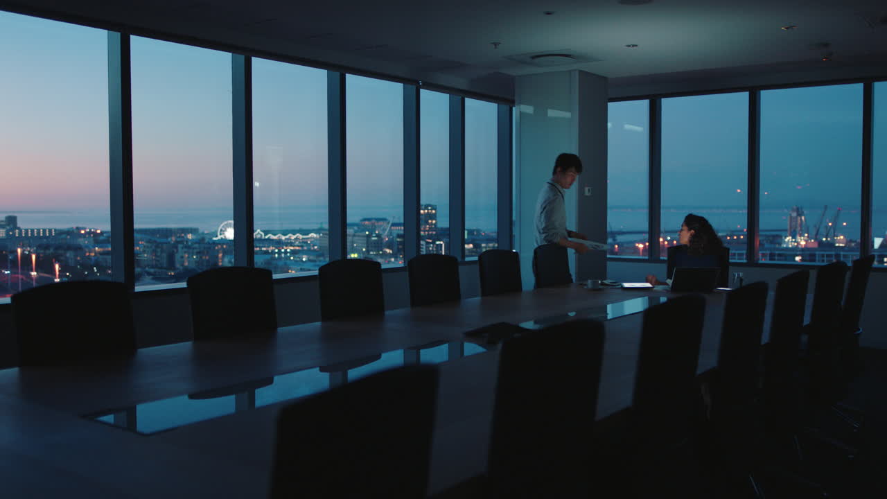 business people working late using laptop computer in office boardroom colleagues work on project with deadline discussing ideas focused on success