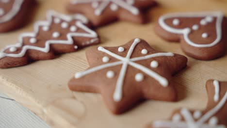 decorating gingerbread cookies for christmas, closeup macro shot making handmade festive new year sweets and cookies with white glaze icing