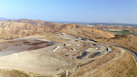 Aerial View of a Large-Scale Waste Management or Landfill Facility in a Hilly Landscape