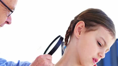 dermatologist examining mole with magnifying glass