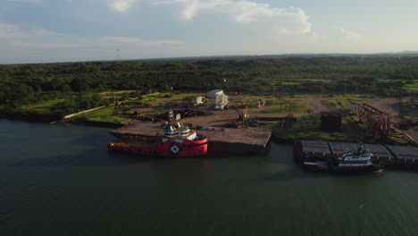un petrolero descargando su carga en un astillero cerca de un río al atardecer