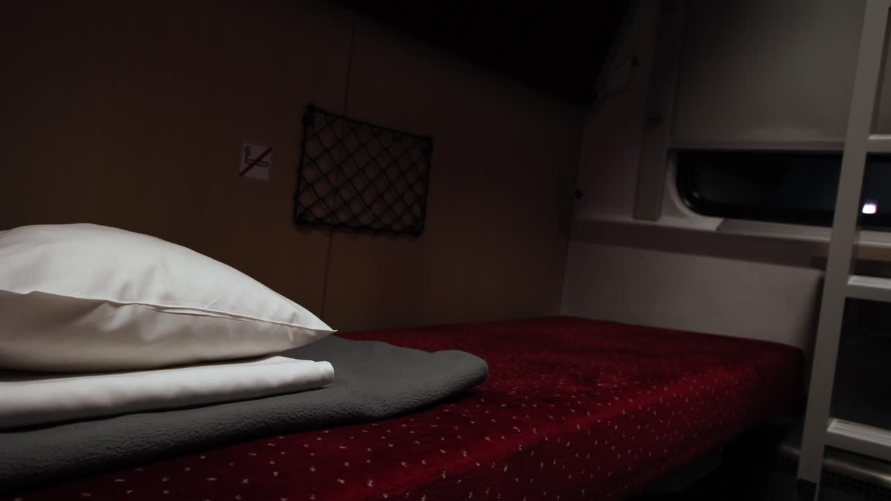 Bed inside a night train, passenger cabin in a moving train