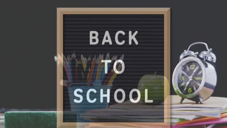Back-to-school-text-on-black-board-against-color-palette--and-geometrical-instruments-icon