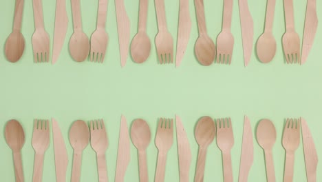 eco friendly zero waste eating utensil made of bamboo wood on two sides of green theme. stop motion