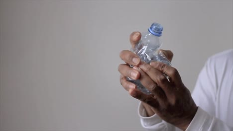 man crushing an empty recycle plastic bottle before recycling stock video stock footage