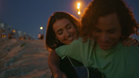 una pareja tocando la guitarra al atardecer.