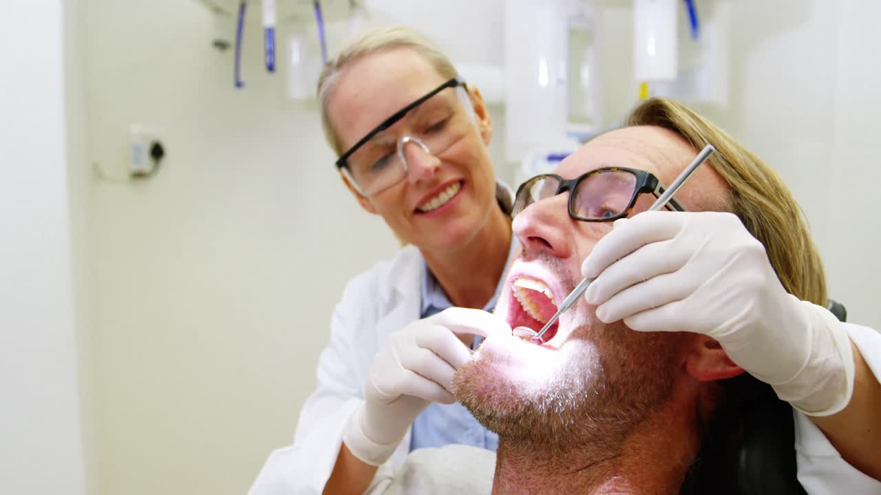 una dentista examinando a un paciente con herramientas